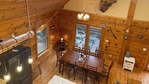 A wooden cabin interior with a dining area, a mounted deer head, and a large window. - 4-bedroom 3 full bath, house in amazing Lake Geneva with AC. (Lake Geneva)