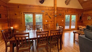 A rustic cabin interior with a dining area, wooden walls, and a mounted deer head. - 4-bedroom 3 full bath, house in amazing Lake Geneva with AC. (Lake Geneva)