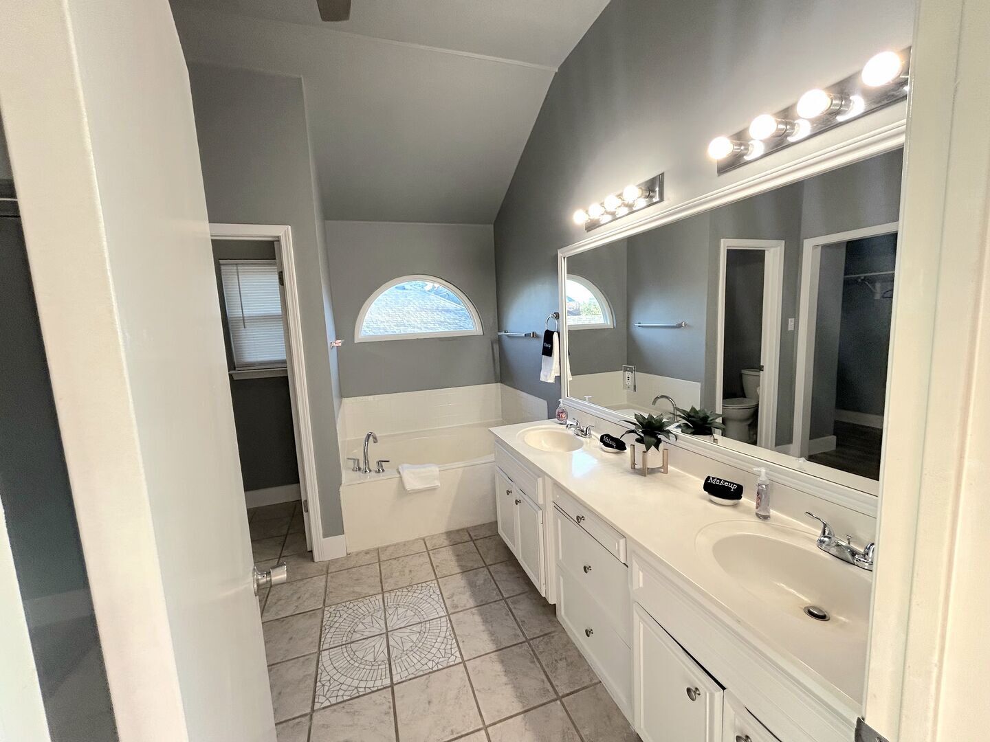 A modern bathroom with a large vanity, a bathtub, and a walk-in shower.
