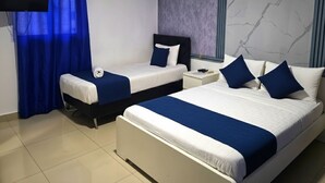 Habitación de hotel con dos camas, un televisor de pantalla plana, una ventana con cortinas y una pared con diseño de mármol.