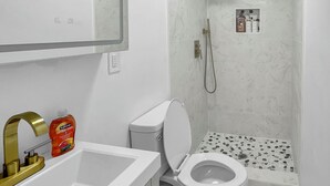 Une salle de bain avec des toilettes, un lavabo et une douche.