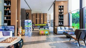 A modern interior with a foosball table, seating area, and bookshelves.