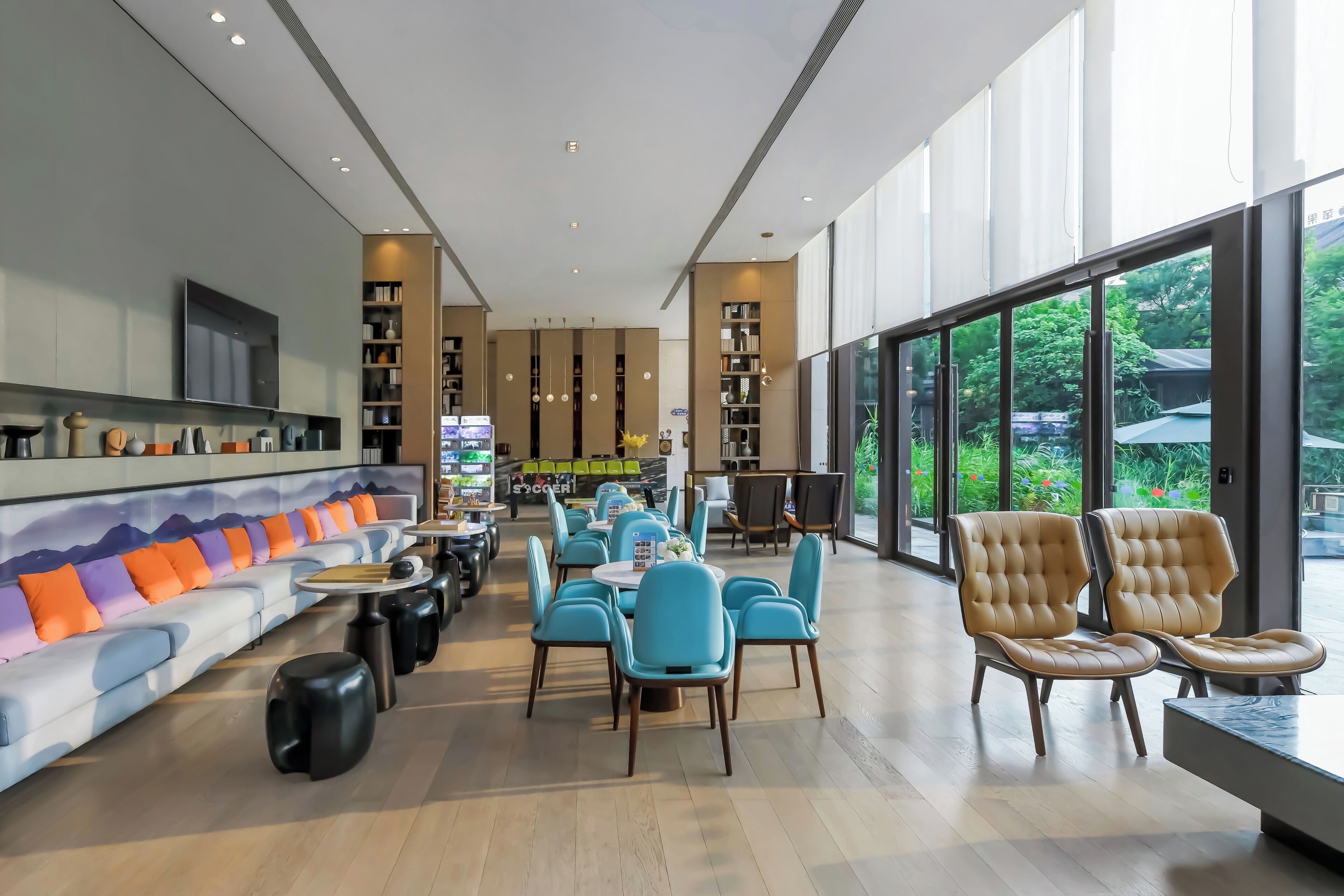 A modern interior with a sofa, chairs, tables, and a TV.
