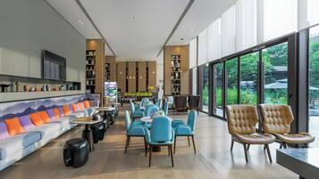 A modern interior with a sofa, chairs, tables, and a TV.