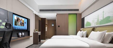 A modern hotel room with a large bed, a TV mounted on the wall, a desk with a chair, and a green door.
