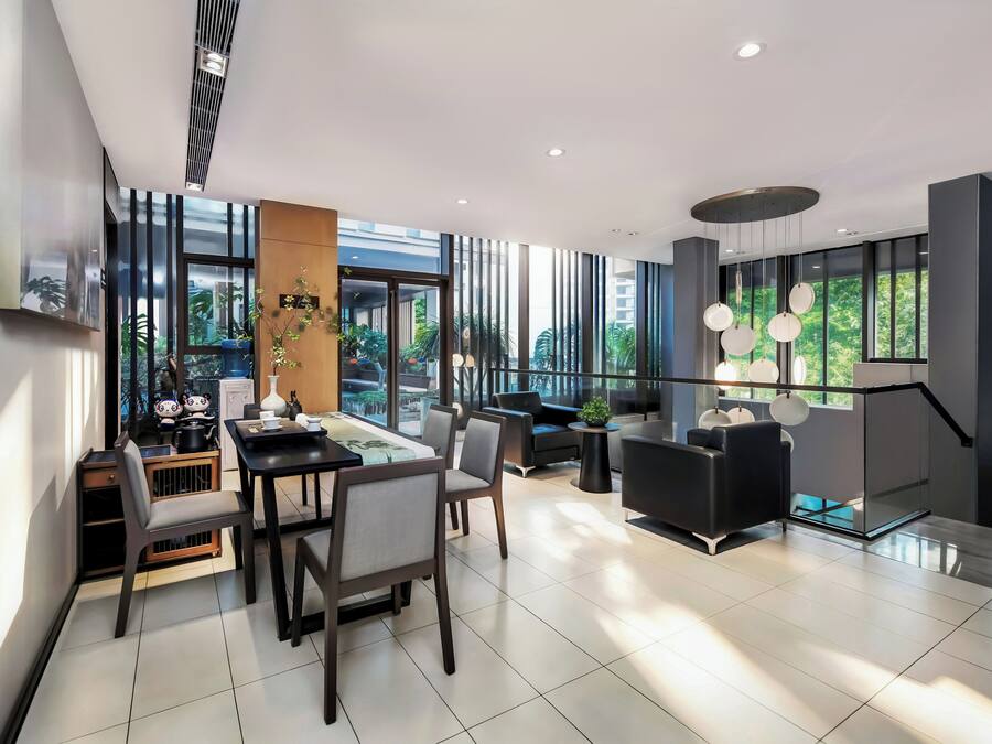 Un interior moderno con comedor, asientos y grandes ventanales que ofrecen vistas.