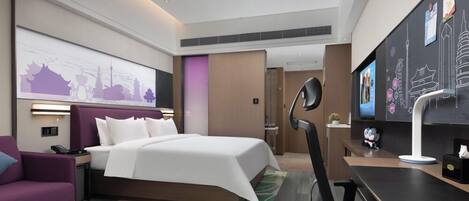 Una habitación de hotel moderna con una cama grande, un escritorio, una silla, un sofá y un televisor.