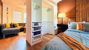 A bedroom with a bed, a wardrobe, a sofa, and a lamp. - Romantic Lakefront Getaway with Balcony near Downtown Orlando (Orlando)