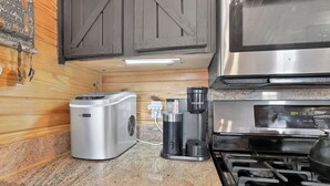A kitchen with a coffee maker, a kettle, and a stove. - Hummingbird Heaven! Woodland Park Mountain Cabin (Woodland Park)