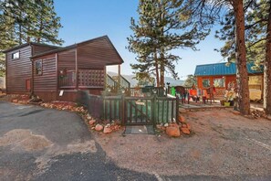 Eine Hütte mit Veranda und umzäunter Garten.