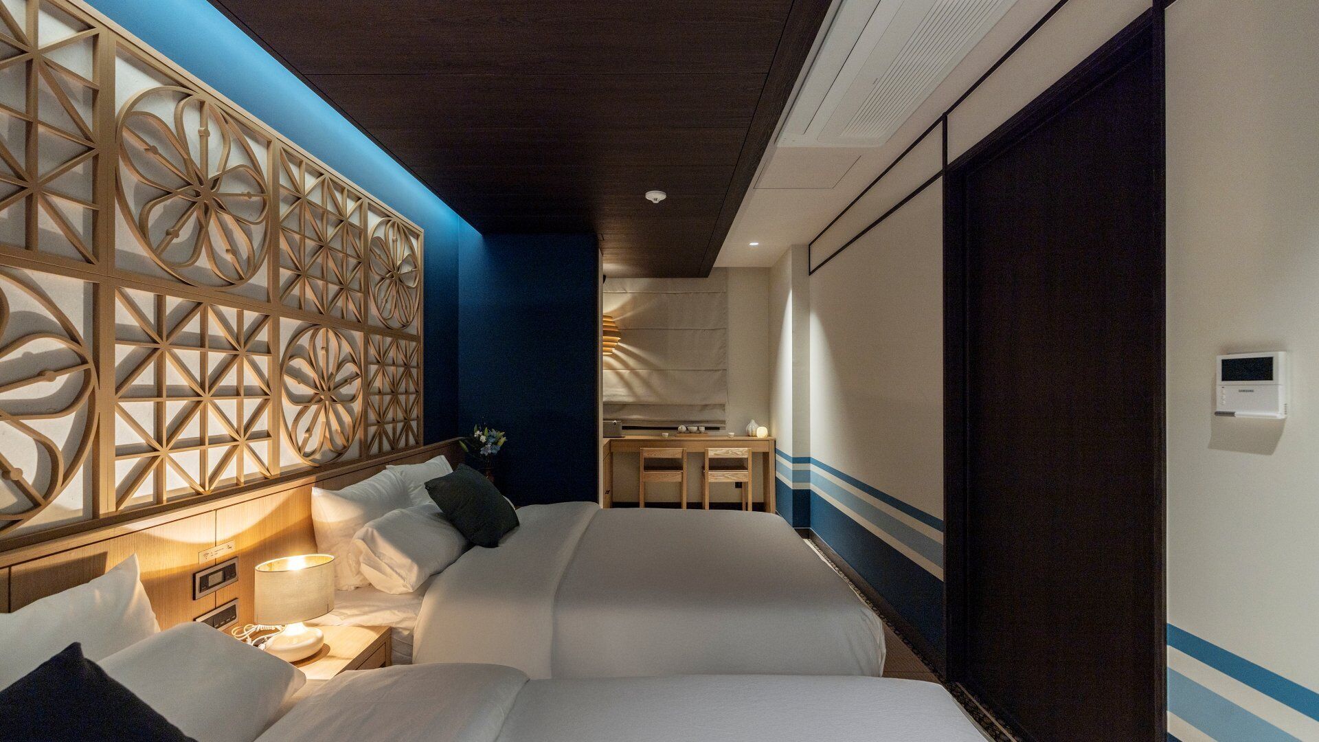 Ein Hotelzimmer mit Bett, Nachttischen, Schreibtisch und Stuhl.
