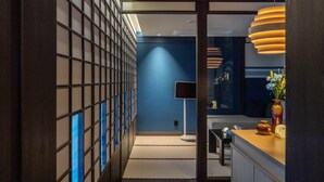 A modern hotel corridor with a blue wall, a black floor lamp, and a reception desk with a vase of flowers. - Stay Passport Okinawa Ryokan Bupyeong Incheon (Incheon)