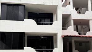A multi-story building with balconies, a swimming pool, and a ceiling fan.