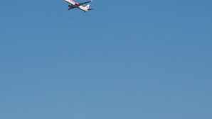 Helderblauwe lucht met een passagiersvliegtuig in de lucht.