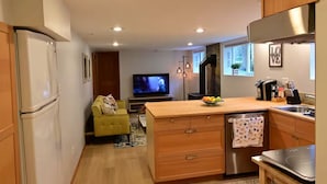 Een moderne keuken met houten kastjes, een inbouwoven en een roestvrijstalen spoelbak.