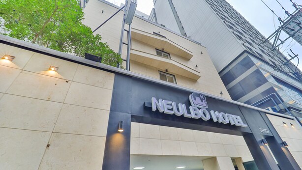 The exterior of the Neulbo Hotel with a modern facade, a visible entrance, and a parking area. - Sloth Hotel Busan Seomyeon (Busan)