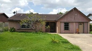 A single-story house with a front porch, a garage, and a small yard. - FIFA Friendly - Large Groups Allowed (Houston)
