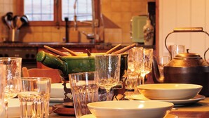 A kitchen with a sink, cabinets, and various kitchenware including glasses, a teapot, and a green bottle. - Les Agettes 1865 by Interhome (Les Mayens-de-Sion)