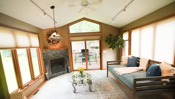 A spacious living room with a fireplace, a sofa, and a dining area.