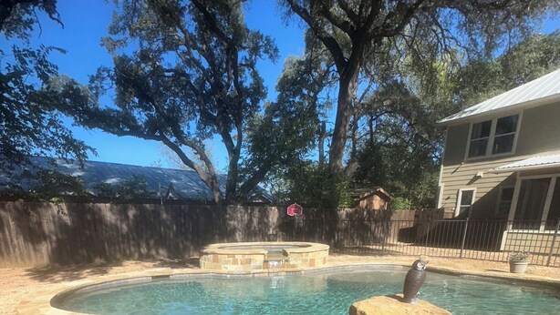 Ein Garten mit Schwimmbecken, Steinstufen und einer Vogelstatue.
