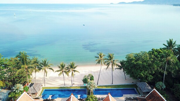 Ein Resort mit Pool, Strand und Palmen.