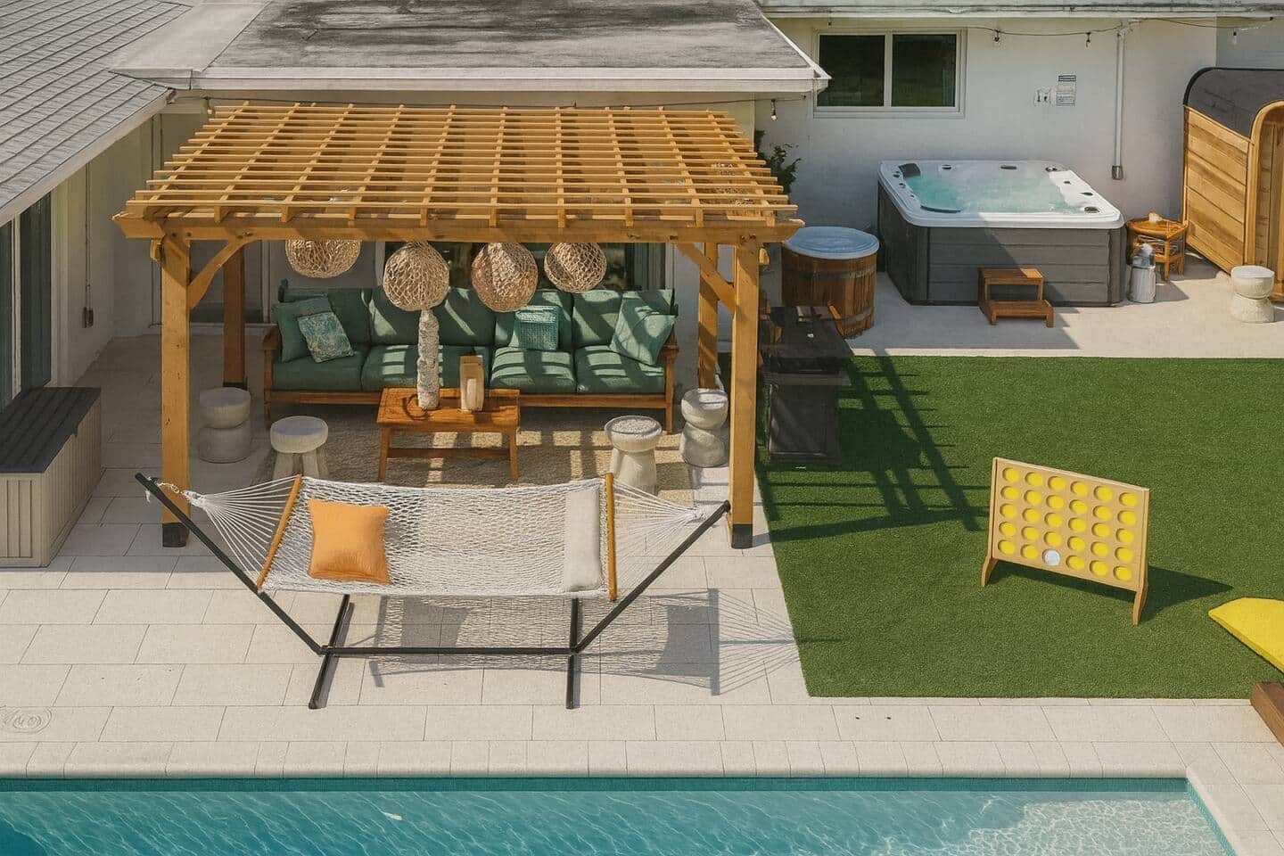 A backyard with a pool, a wooden pergola, a hot tub, and outdoor seating.