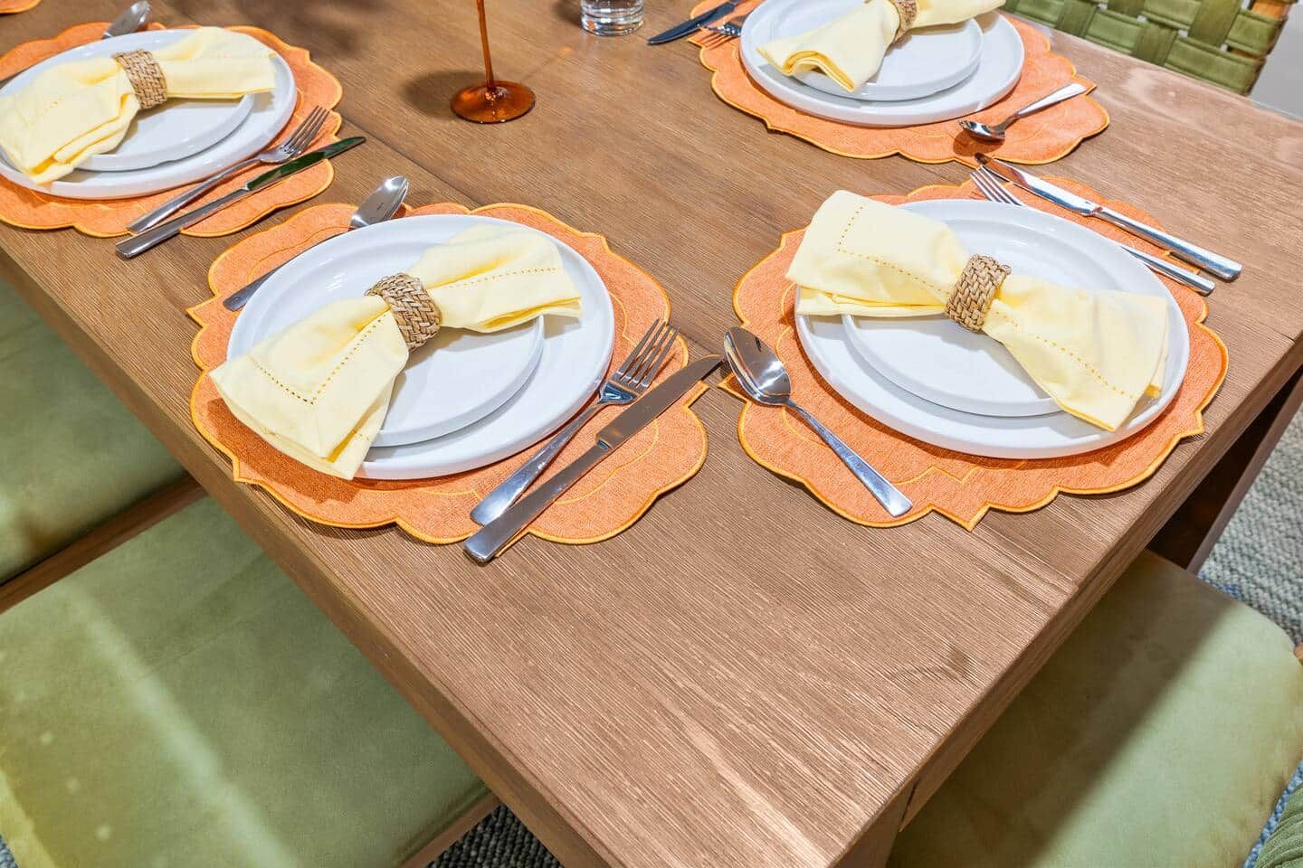 Una mesa puesta con platos, cubiertos y servilletas.