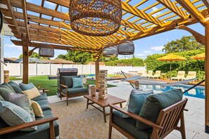 An outdoor patio with a wooden pergola, seating area, and a pool. - Wellness Retreat at WPB - HotTub | Sauna | ColdPlunge | Golf (West Palm Beach)