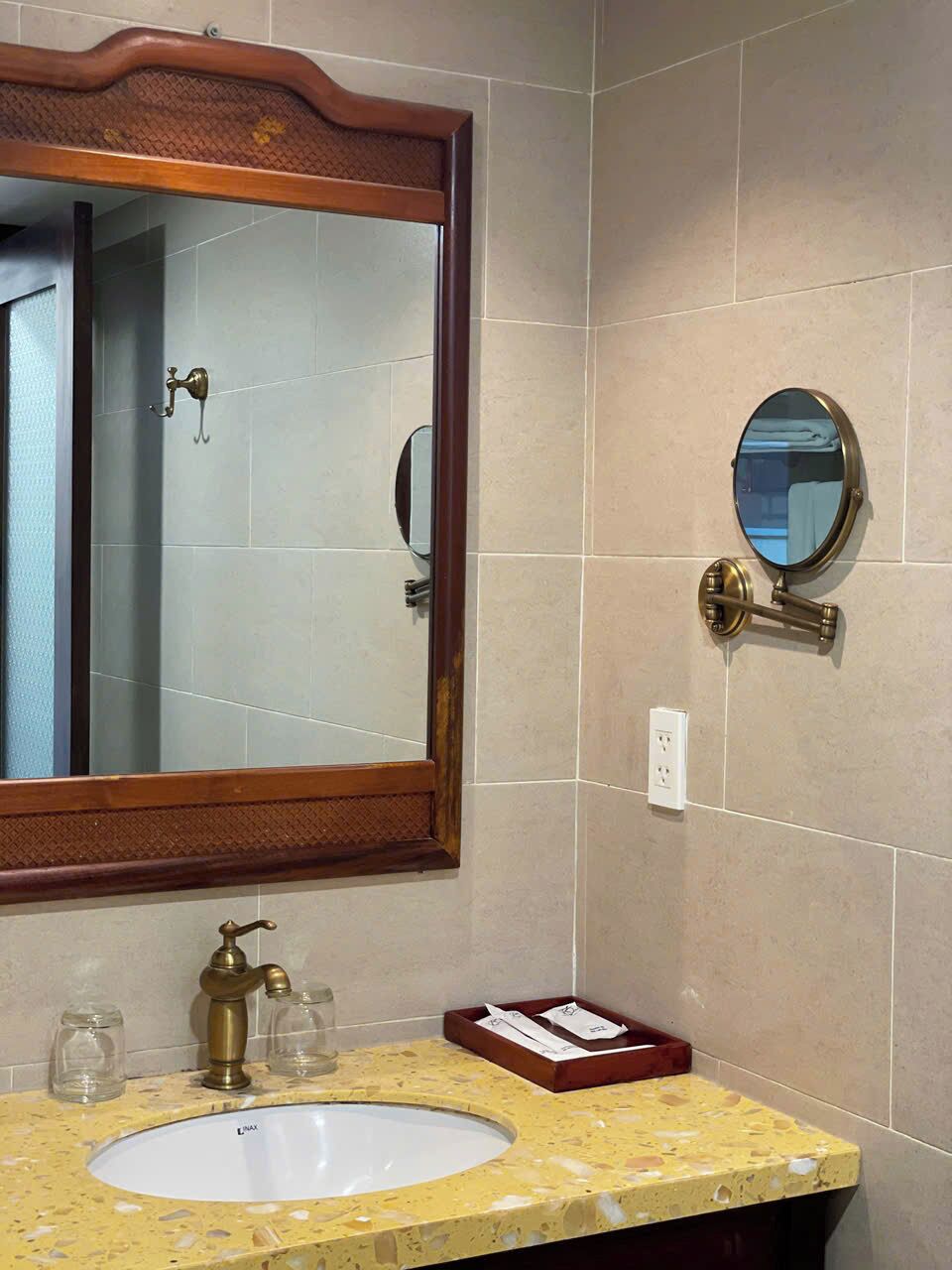 A bathroom with a large mirror, a sink, and a towel rack.