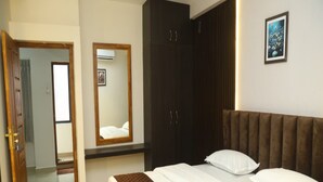 Un dormitorio con cama, armario, espejo y un cuadro en la pared.