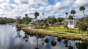 A lakeside property with a gazebo, a large white house, and palm trees. - Riverbend Landing - Steinhatchee (Steinhatchee)