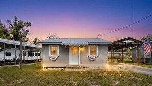 A small single-story house with a front porch, a garage, and an American flag. - Fenway Fiddler - Steinhatchee (Steinhatchee)