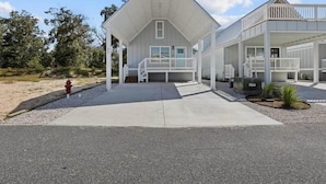 A two-story building with a flat roof, a covered porch, and a small garden area. - The Pelican Pad - Steinhatchee (Steinhatchee)