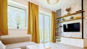 Un salon moderne avec un canapé, une table basse et un téléviseur fixé au mur.