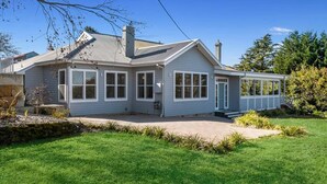 A single-story house with a covered porch, a front yard, and a small garden area.