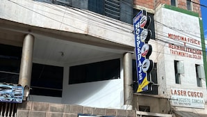Un edificio con insegna per centro medico e di riabilitazione, ingresso visibile e cancello in metallo.