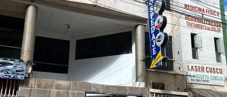 A building with a sign for a medical and rehabilitation center, a visible entrance, and a metal gate.