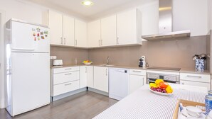 A modern kitchen with white cabinets, a built-in dishwasher, and a stainless steel range hood. - TUGORES SIMÓ 2º A - Charming apartment on the beachfront in Can Picafort – Free Wi-Fi (Muro)