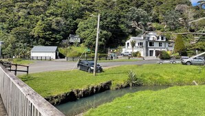 A residential area with houses, a road, and a small stream. - Entire home in Auckland, New Zealand (Auckland)