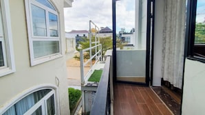 A residential balcony with a view of neighboring houses and a clear sky. - GOLD KIM PHÚ - Hotel Da Lat (Cam Ly - Da Lat)