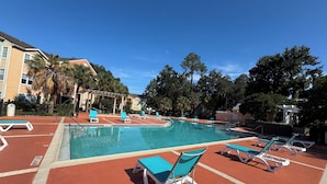 A swimming pool with lounge chairs and a red deck area. - Spacious 4-bedroom apartment centrally located and near UF and Shands Hospital (Gainesville)