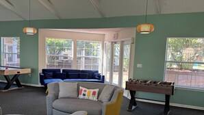A room with a pool table, a foosball table, a sofa, and a couch. - Spacious 4-bedroom apartment centrally located and near UF and Shands Hospital (Gainesville)