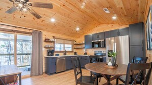 A modern kitchen with wooden cabinets, a dining table, and chairs.