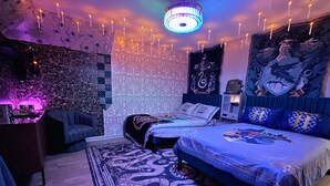 Un dormitorio con una cama, un escritorio y un tapiz de pared.