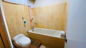 A small bathroom with a toilet, a bathtub, and a shower. - Hommy Inn Timoho (Yogyakarta)