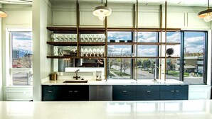 A modern kitchen with a large window, built-in shelves, and a stainless steel sink.