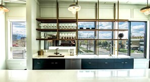A modern kitchen with a large window, built-in shelves, and a stainless steel sink.