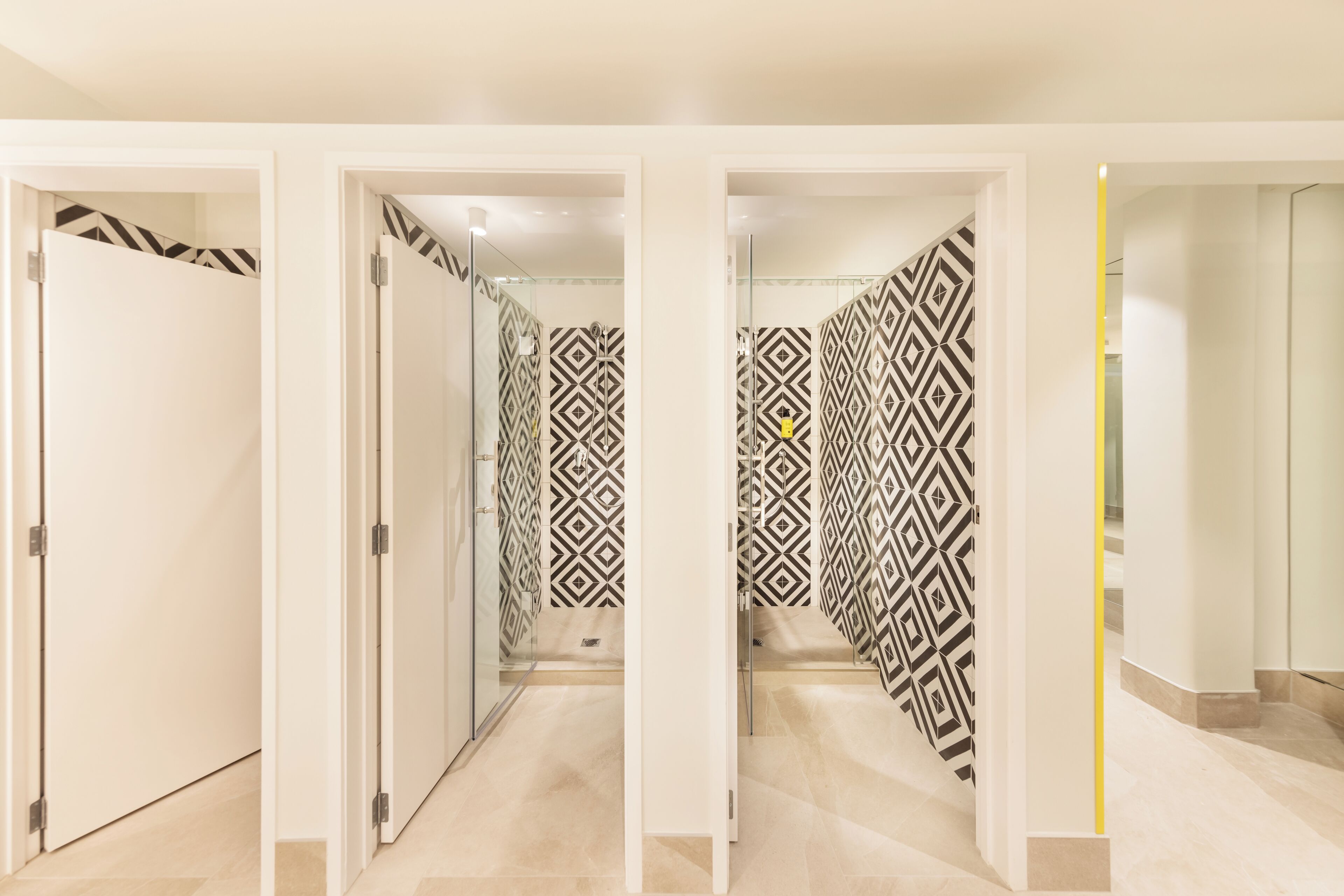A hallway with mirrored walls and patterned wallpaper.