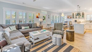 Un salon spacieux comprenant un grand canapé, une table basse et un coin repas avec une chaise et une table.