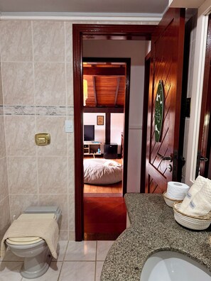 Une salle de bain équipée de toilettes, d’un bidet et d’un lavabo.
